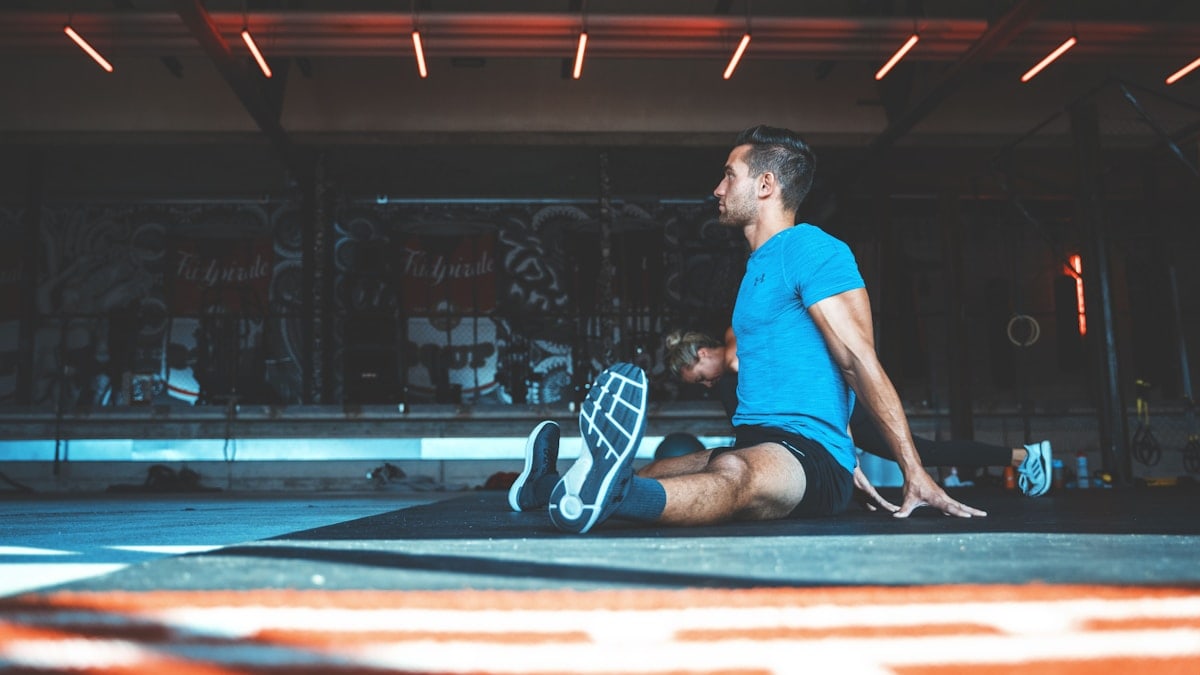 man sitting on exercise mat